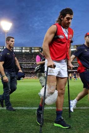 Adelaide forward Taylor Walker leaves the ground on crutches.