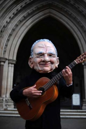 On song ... a protester in a Rupert Murdoch mask in London.