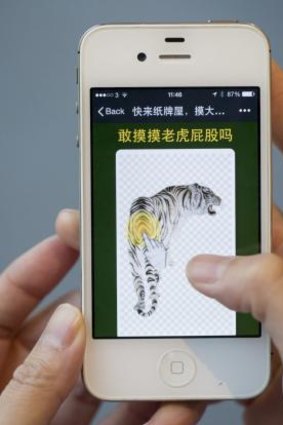 A user of the WeChat messaging app plays the game "Brave enough to touch the tiger's butt?". The game examines the web of corruption around fallen Chinese official Zhou Yongkang, after Chinese President Xi Jinping vowed to tackle both "tigers and flies" in fighting graft.