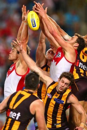 At a stretch: Sydney's Shane Mumford (right) attempts a pack mark against Hawthorn at ANZ Stadium on Friday night.
