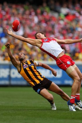 The Swans' Shane Mumford, right, attempts to mark in front of Hawthorn's Josh Gibson during the yesterday's grand final.