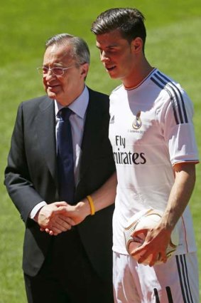 Real Madrid president Florentino Perez shakes hands with Bale as they pose for the cameras.