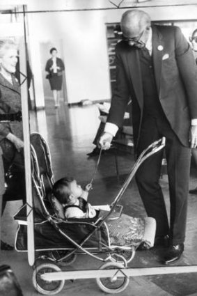 Dr Benjamin Spock greets a patient in Melbourne, one-year-old Robert Barter.