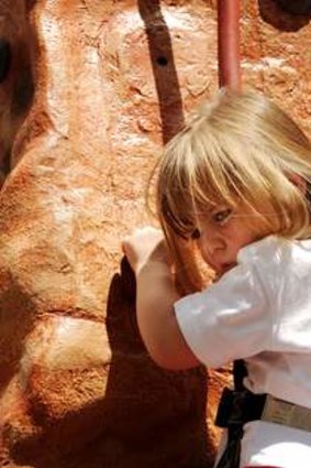 Emily Harcher, 3, on the rock climbing wall that has been set up in Garema Place.