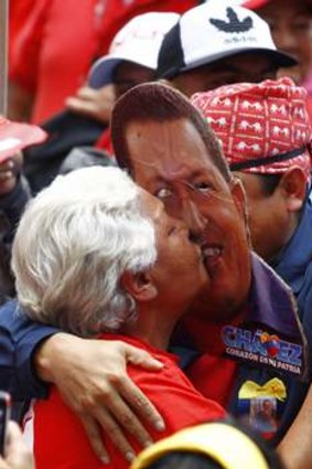 Real devotion ... a supporter of Hugo Chavez kisses another supporter wearing a mask depicting him during a rally in Caracas.