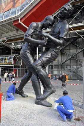 Employees work in Paris near a bronze sculpture by Algerian artist Adel Abdessemed, immortalising the headbutt given by the French champion Zinedine Zidane to Italian Marco Materazzi during the World Cup final in 2006.