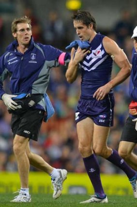 Fremantle's Luke McPharlin leaves the field with an injury on Friday after being bumped by Essendon's Patrick Ryder.