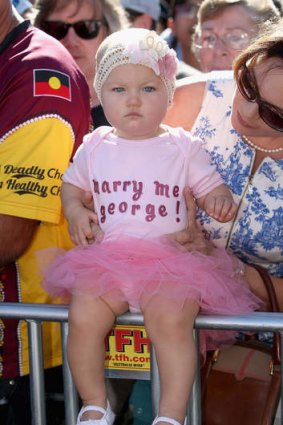 10 month old Grace Farrelly waits for a royal walkabout wearing a babygrow that says 'Marry Me George' at South Bank.
