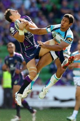 Melbourne fullback Billy Slater leaps high to defuse a bomb against Gold Coast.