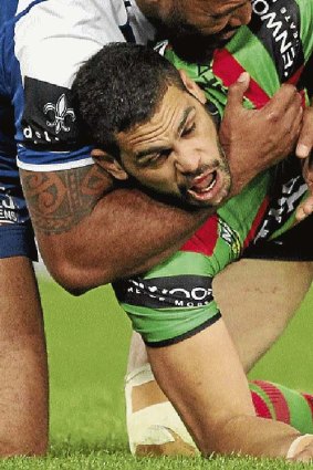 Biting back: Greg Inglis is taken around the throat in a tackle.