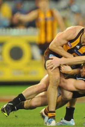 Hard man to keep in check: Hawthorn's Luke Hodge is brought to a halt, but it took the efforts of Jarryd Blair and Dayne Beams to do it.