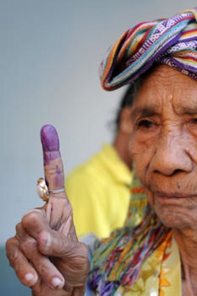 Democratic process ... an East Timorese woman shows her inked finger at a polling centre in Dili on Monday.