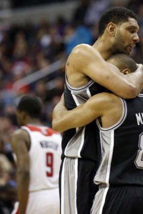 San Antonio Spurs forward Tim Duncan gives guard Patty Mills a bear hug during the win over Washington. Duncan had 31 points and Mills had 23 in their 125-118 double overtime win.