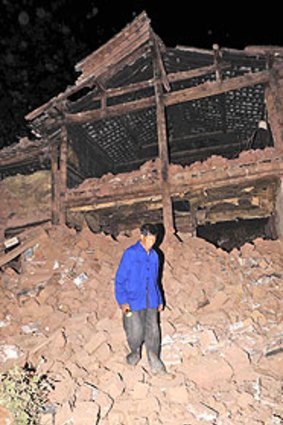 A villager wanders through the rubble of a house in Yunnan province, which was hit by a moderate but destructive earthquake.
