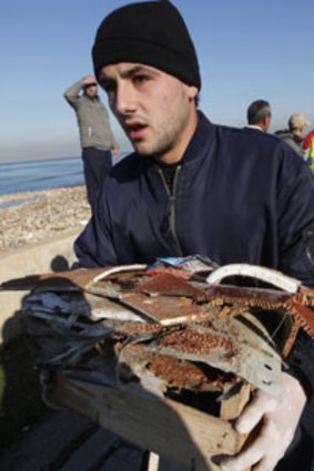 A Lebanese civil defense worker gathers debris washed ashore from the wreckage of the Ethiopian Airlines Boeing 737 plane.