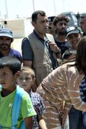 Helping hand … Princess Mary talks to children during a visit to a refugee camp in Jordan in August.
