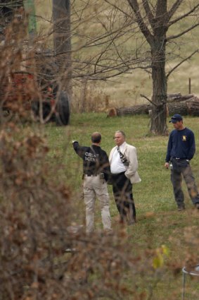 Lafayette County Sheriff Kerrick Alumbaugh, centre, talks to investigators as they search for evidence on a rural property near Bates City, Missouri.