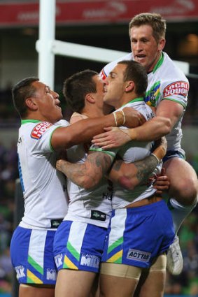 Raiders players celebrate a try against the Storm tonight.
