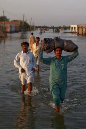 Villagers displaced from their homes by flooding make their way through flood waters in Punjab, Pakistan, earlier this year.