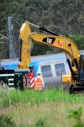 Cranes wait to lift the carriages after the train crash at Dandenong South last November.