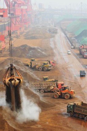 A crane drops iron ore imported from Australia at a port in Rizhao, in east China's Shandong province.