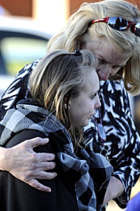 A woman embraces a girl outside Deer Creek Middle School in Colorado after two students were shot.