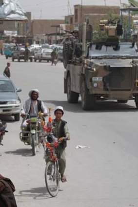 A Bushmaster drives through Tarin Kowt town during an operation to inspect a new road in Oruzgan province.