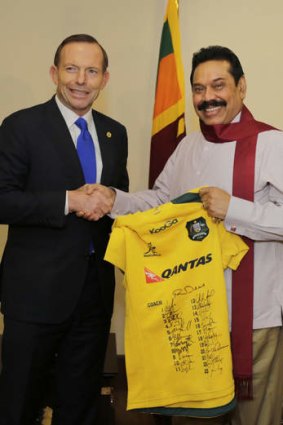 Prime Minister Tony Abbott gives Sri Lanka's President Mahinda Rajapaksa a signed Australian Rugby Union jersey in Colombo.