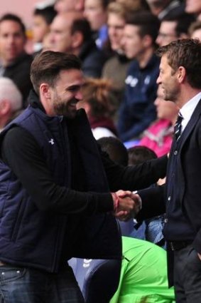 Tottenham Hotspur's English Manager Tim Sherwood (R) invites an unidentified spectator to take his seat in the dugout.