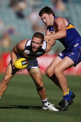 Joel Selwood of the Geelong Cats gets tackled by Jeremy McGovern of the West Coast Eagles.
