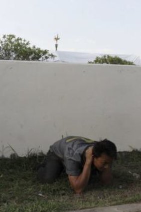 A man is detained after Thai soldiers entered a pro-government "red shirt" camp in Nakhon Pathom province on the outskirts of Bangkok.