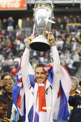Los Angeles Galaxy's David Beckham holds the trophy after the Galaxy defeated the Houston Dynamo to win the MLS Cup championship.