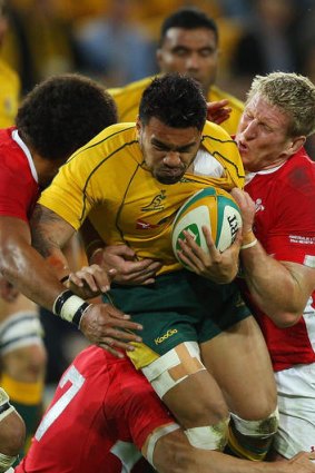 Coming through: Wallaby Digby Ioane tries to crash through his Welsh opponents during last night's game at Suncorp Stadium.