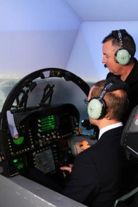 His Royal Highness, the Duke of Cambridge (left) experiences a flight in the F/A18-F Super Hornet simulator under the guidance of Mike Prior, Training Services Manager for Milskil (centre) and Flight Lieutenant Jasper McCaldin.
