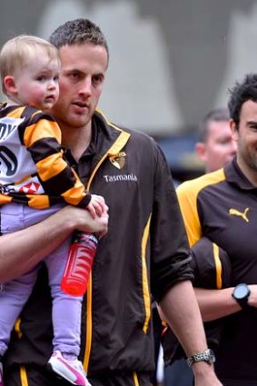 Hawk David Hale gets some support from a small companion and fellow Hawk Jordan Lewis during the annual Grand Final parade through Melbourne streets.