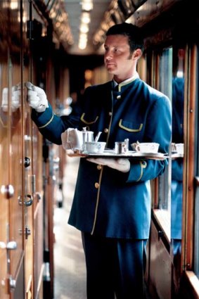A cabin steward delivers afternoon tea to a compartment on Europe's famed luxury train service, the Orient Express.