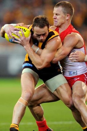 Brad Sewell is wrapped up by Sydney's Ryan O'Keefe at the MCG on Saturday.