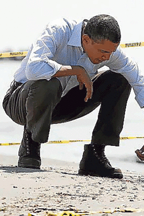 Barack Obama looks at tar balls.