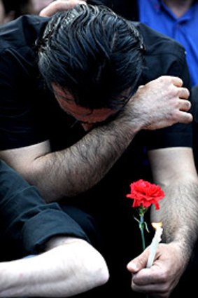 A man holds a flower and candle as he mourns during a ceremony in Taksim Square, Istanbul.