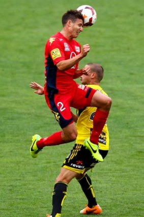 Adelaide United's Michael Marrone beats the Phoenix's Matthew Ridenton to the ball during the crucial A-League clash.
