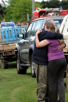 A woman, believed to be the mother of one of the children, is consoled at the scene.