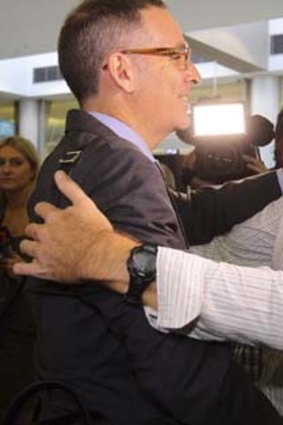 Haking off the dust of Dubai: Marcus Lee, right, embraces his lawyer John Sneddon.