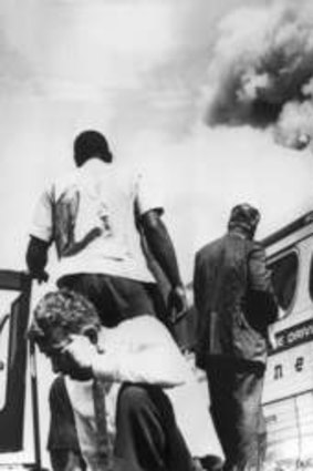 Freedom riders outside a Greyhound bus that was set alight by whites in Alabama in May 1961.