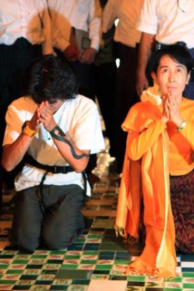 First trip outside Rangoon since 2003 ... Aung San Suu Kyi, right, and her youngest son, Kim Aris, pray at Arnanda Pagoda in Bagan, Burma, yesterday.
