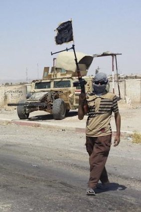 A fighter of the Islamic State of Iraq and the Levant (ISIL) stands guard at a checkpoint near Baiji.