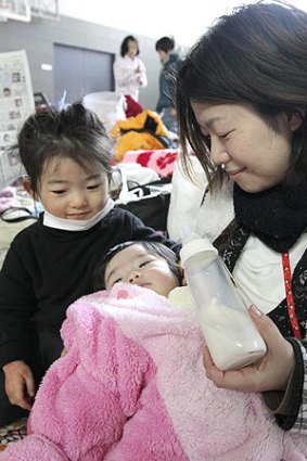 Eriko Ohara, who lost her husband last week, feeds her child milk.