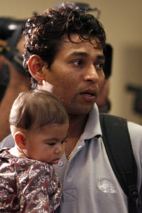 Team member ...   Thilakarathna Dilshan holds his daughter on his return.