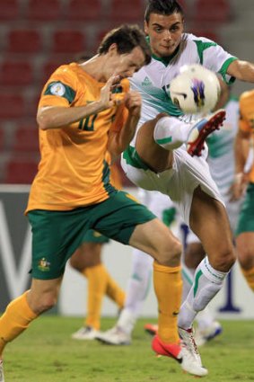 Taking one for the team ... Robbie Kruse of Australia competes with Ahmed Yaseen Gheni of Iraq.