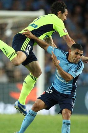 Melbourne Victory's Mark Milligan pressures Sydney FC's Ali Abbas.