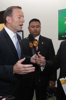 Prime Minister Tony Abbott speaks with an Australian-based journalist who was not allowed to his press conference during the East Asia Summit in Brunei.